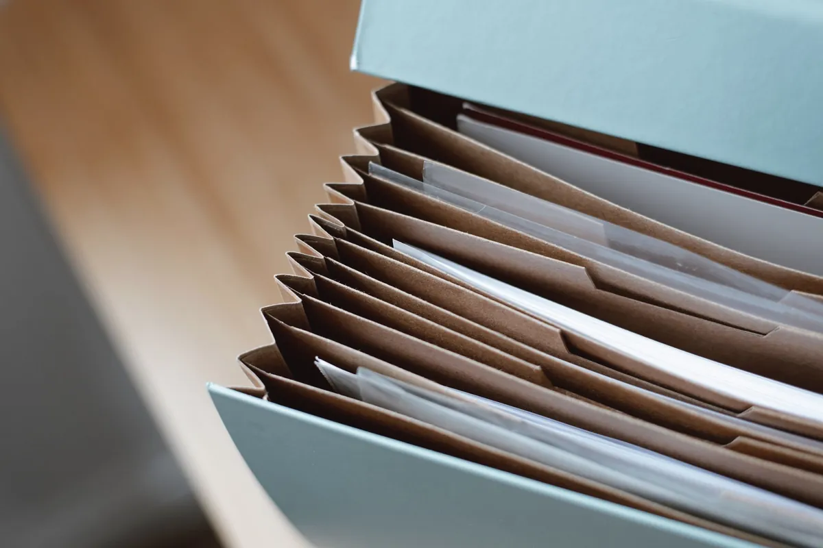 Hellblaue Dokumentenbox mit sortierten Mappen und Papieren